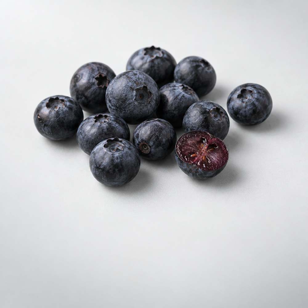 Bilberries with one berry cut to show its purple flesh